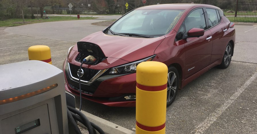 A Nissan Leaf, which is a fully electric vehicle, is connected to a charging station.
