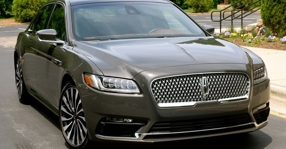 A Lincoln Continental is parked in a driveway.