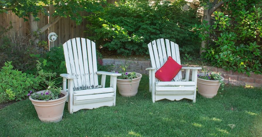 A lush backyard with lawn chairs. Before summer arrives, here's how you can get your lawn ready for the warmer months.